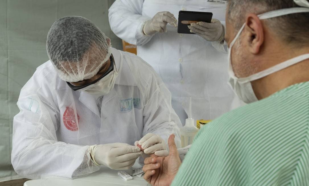 Profissional de saúde realizando teste rápido de paciente em um hospital do Rio de Janeiro. (Fonte: Agência O Globo/Leo Martins/Reprodução)