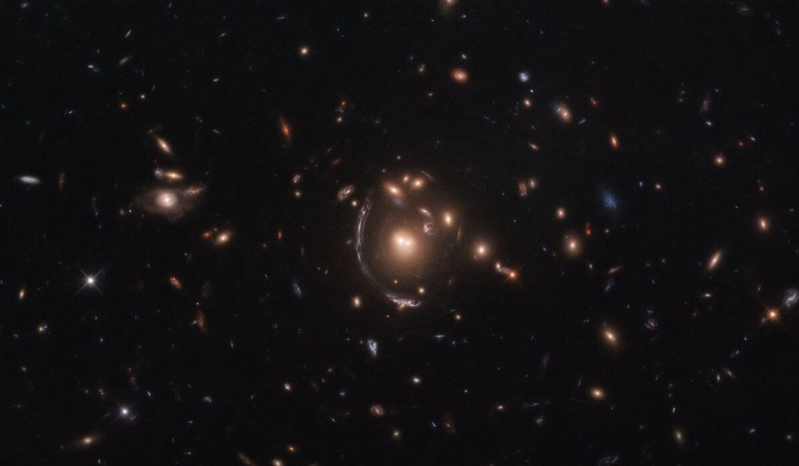 A imagem acima foi fotografada pelo Telescópio Espacial Hubble e apresenta uma distorção causada por lentes gravitacionais, um fenômeno previsto por Albert Einstein.