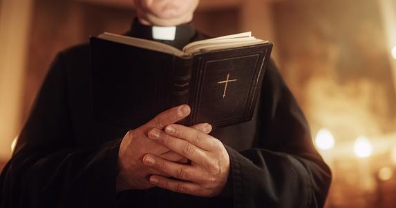 Imagem de um padre segurando a Bíblia. (Fonte: GettyImages)